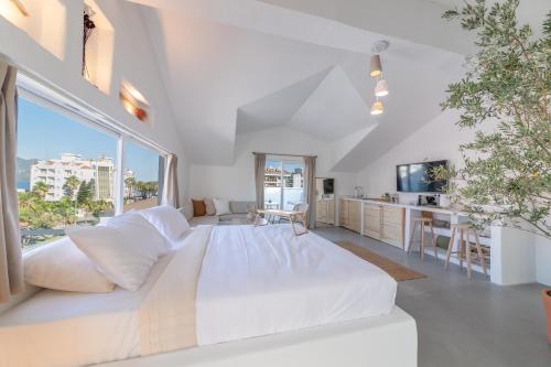 马尔马里斯L'olive homes的一张大白色的床,位于一个设有大窗户的房间