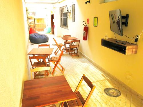 里约热内卢Hostel Estação Maracanã的餐厅设有木桌、椅子和电视。