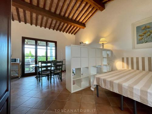 切奇纳Small cottage with aircon, private terrace and garden - 2000m from the beach by ToscanaTour的一间卧室配有一张床和一张桌子及椅子