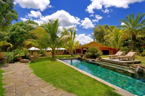 沙马雷勒哈马独家洛奇酒店的一个带游泳池和棕榈树的后院