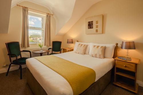 丁格尔码头畔住宿加早餐酒店的一间卧室设有一张大床和一个窗户。