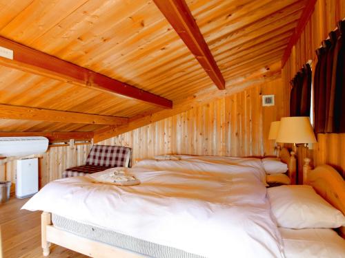 出云市Ichihatakeyama cottage - Vacation STAY 82831的卧室设有一张木制天花板上的大床