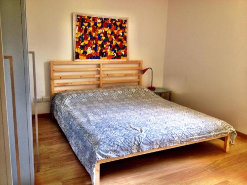 弗留利地区奇维达莱Casa Romea的卧室配有一张床,墙上挂有绘画作品