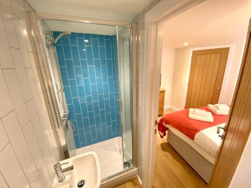 福伊Crimpers Cottage的带淋浴和盥洗盆的浴室以及1张床。
