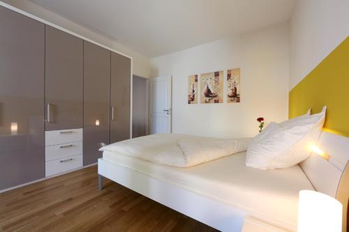 慕尼黑商务套房酒店的卧室配有白色大床和橱柜