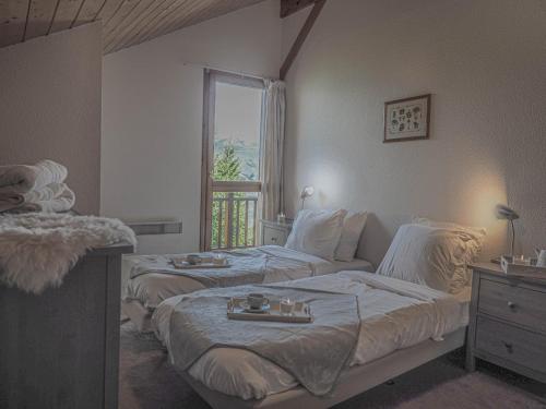 佩塞克鲁瓦La Belle Maison的一间卧室设有两张床和窗户。