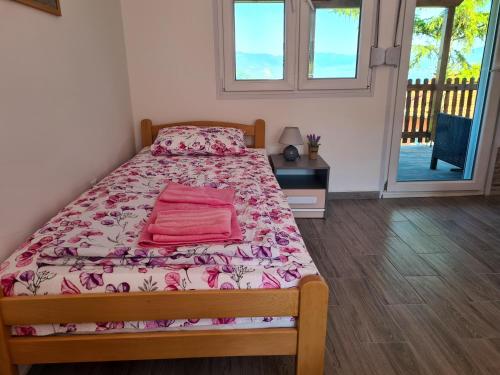 下米拉诺瓦茨Apartmani Kuljanin的一间卧室配有一张带粉色床单的床和一扇窗户。