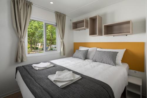波雷奇Camping Ulika Mobile Homes - Naturist的一间卧室配有一张床,上面有两条毛巾