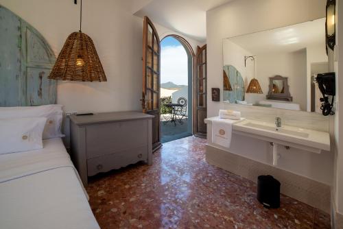 厄尔·波索·德·洛斯·弗莱尔Finca Maltes San José的浴室设有床、水槽和镜子