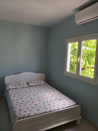 MbouiniCiel du sud的卧室内的一张床位,带窗户