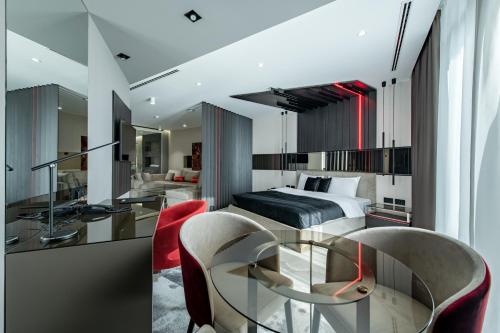 克拉古耶瓦茨日内瓦豪华酒店的一间卧室配有一张床和一张玻璃桌子及椅子