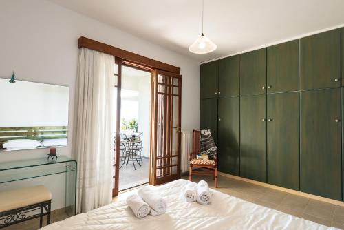 佩基罗德Emerald Dawn Villa的一间卧室设有绿色橱柜、一张床和一个阳台。
