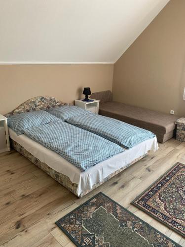 巴拉顿博格拉尔Fanni Vendégház的卧室配有一张床,地板上铺有2个地毯。