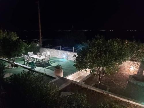 索瓦拉Elia Villa - Aegina, Souvala的庭院在晚上配有桌椅
