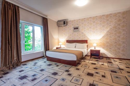 第比利斯马戈皇宫酒店的一间卧室设有一张床和一个大窗户
