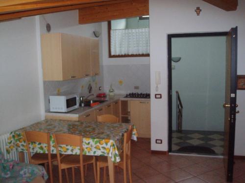 斯波尔马焦雷Casa Osti的一个带桌椅和门的小厨房