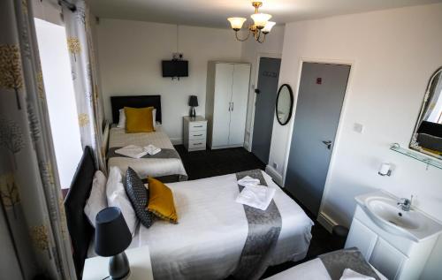 利物浦St Hilda Guesthouse的酒店客房设有两张床和盥洗盆