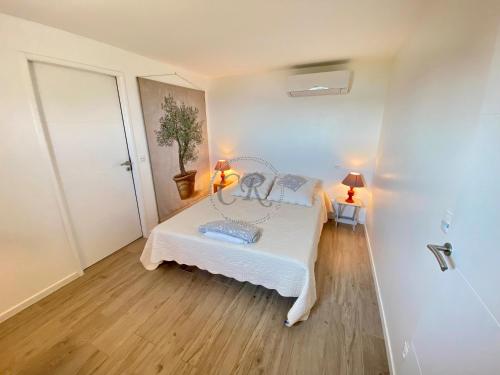 勒拉旺杜T2 standing 800m de la plage de St Clair的铺有木地板的客房内设有一间卧室和一张床。