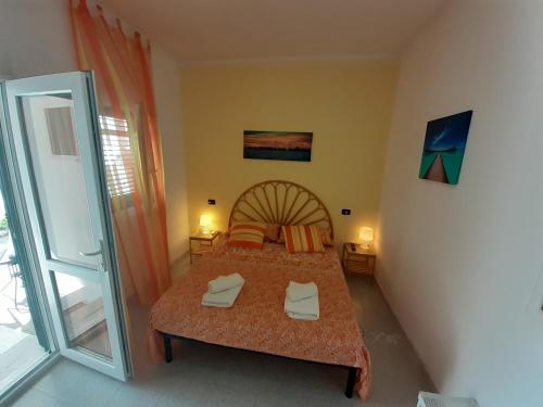 托里德欧索Casa Vacanza Fiorella的一间卧室设有一张床和一个滑动玻璃门