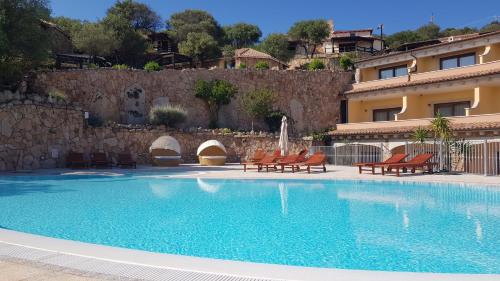 奥尔比亚帕佐萨科罗酒店的一座带椅子的游泳池以及一座建筑