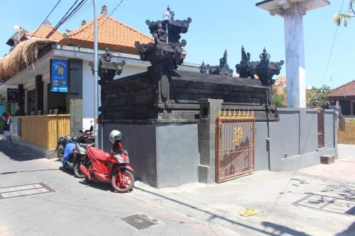 库塔Jukung Villas Kuta的停在大楼前的一辆红色摩托车