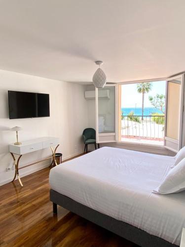滨海卡涅Maison de la Marine的一间卧室配有一张床、一张书桌和一个窗户。