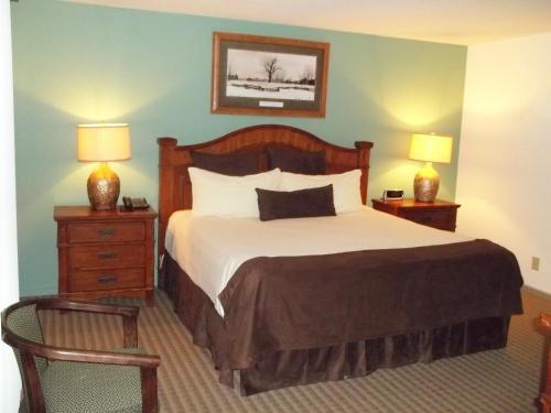 卢尔湖Fox Run Association, a VRI resort的一间卧室配有一张带2个床头柜和2盏灯的床。