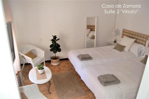 萨莫拉La Casa de Zamora的卧室配有一张白色大床和一把椅子