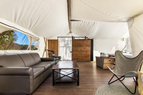 鸽子谷Under Canvas Great Smoky Mountains的客厅配有沙发和帐篷内的桌子