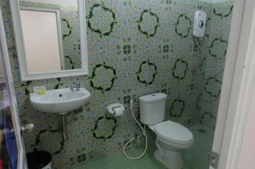 塔可克海滩Tubkaek mansion的一间带卫生间、水槽和镜子的浴室