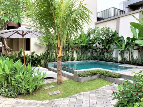 登巴萨迪大厦酒店的棕榈树花园中的游泳池
