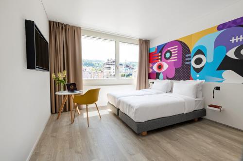 圣加仑B&B HOTEL St Gallen的酒店客房设有一张床和一个大窗户