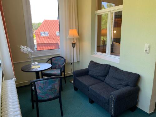 科尔平塞Pension zur Ostsee的带沙发、桌子和窗户的客厅