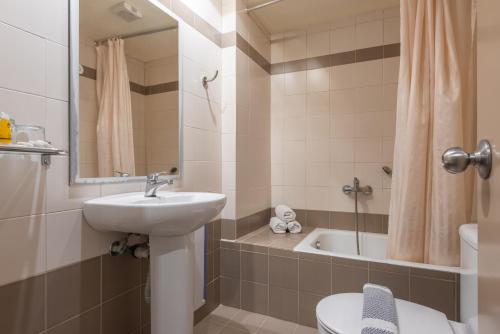 扎金索斯镇宜艾酒店的浴室配有盥洗盆、卫生间和浴缸。