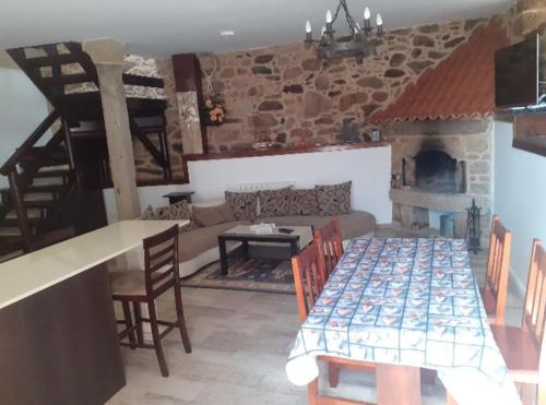 帕德隆Casa Rústica Pedroso的客厅配有桌子和壁炉