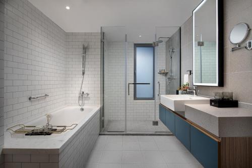 徐州徐州馨乐庭云龙湖公寓酒店的浴室配有2个盥洗盆、浴缸和淋浴。
