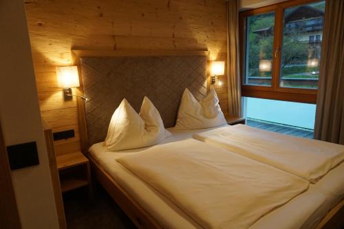 阿特湖畔翁特拉赫克里斯蒂娜公寓的一间卧室配有一张带白色床单的床和一扇窗户。