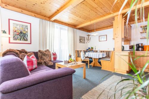维尔芬翁亚历山德拉公寓的客厅配有两张紫色沙发和一张桌子