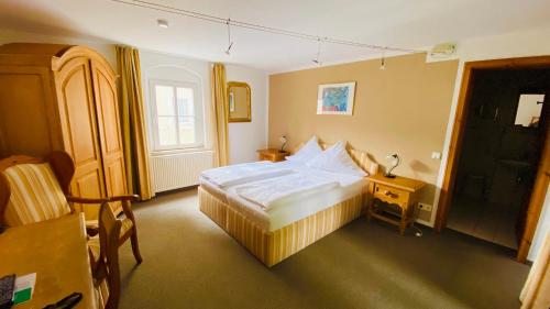巴特尚道尔布格里赫特酒店的一间卧室配有一张床、一张桌子和一个窗户。