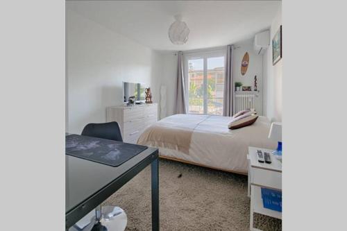 尼斯Charme et Confort pour vos vacances sur Nice的一间卧室配有一张床、一张书桌和一个窗户。