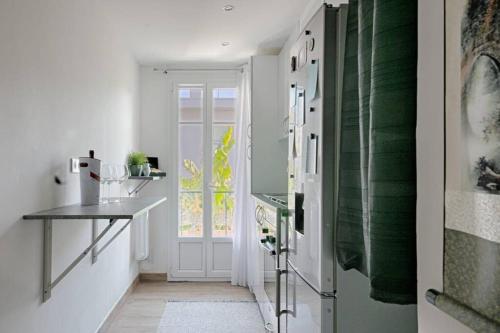 尼斯Charme et Confort pour vos vacances sur Nice的厨房设有白色的墙壁和一扇带窗户的门