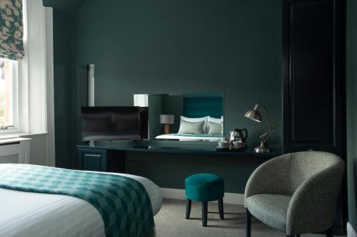 吉夫诺克Orchard Park Hotel的一间卧室配有一张床、一把椅子和镜子