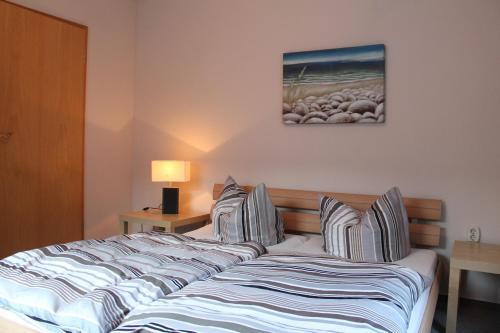 奥斯赛拜-塞林吕根岛公寓的一间卧室配有带条纹枕头的床