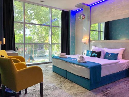 布达佩斯Smart Hotel Budapest & Apartments的一间卧室配有一张大床和一张黄色椅子