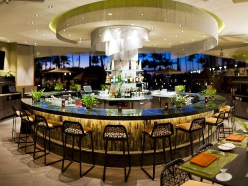 维雷亚毛伊岛凯拉尼费尔蒙酒店的餐厅内的酒吧配有桌椅