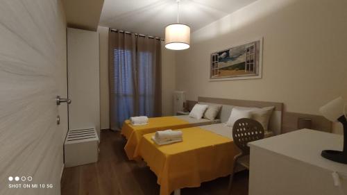 福贾Casa in Fiera的客房设有两张床和一张黄色的桌子及椅子。