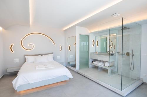 卡尔帕索斯Aros Luxury Villas的一间卧室设有一张床和一个玻璃淋浴间
