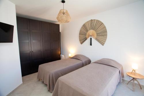 法沃内Les Villas de la Résidence U Veniqui的卧室配有两张床,墙上配有风扇
