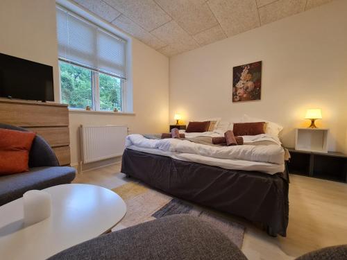 StokkemarkeHotel Stokkegaarden's BnB & Apartments的一间带两张床和一张沙发的客厅