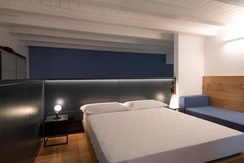 维罗纳Agriturismo Le Grazie的卧室配有一张白色大床和一张蓝色沙发。